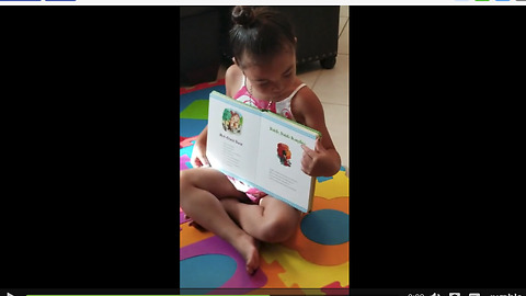 Little girl reads book to her 4-week-old puppies