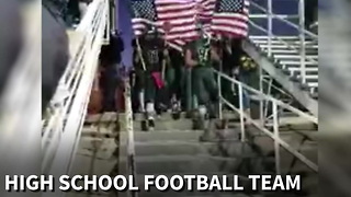 High School Football Team Enters Stadium Carrying American Flags