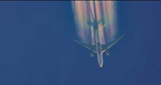 Plane leaves rainbow trail in the sky