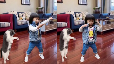 The cute little girl listens to music and dances with funny cats the dance moves are great