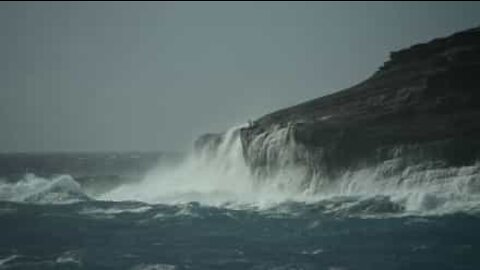 Un homme risque sa vie sur une falaise pour filmer des vagues