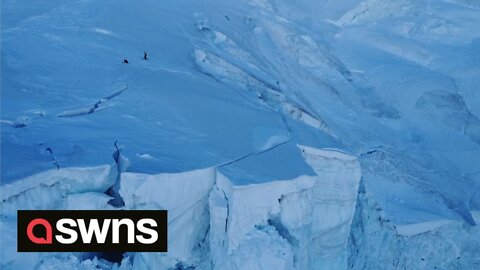 Incredible footage shows thrill-seeker friends ski-base jumping on dangerous glacier