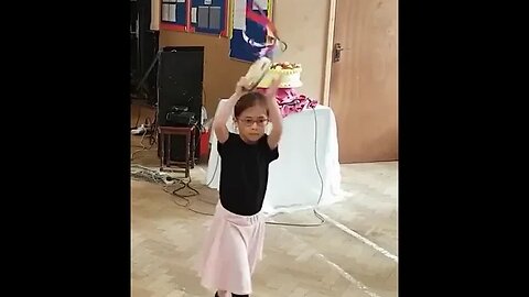 Cute little girl is dancing and praising the Lord by dancing at tambourine worship