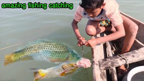 Young boy catching big fish by chicken/Catching fish from river