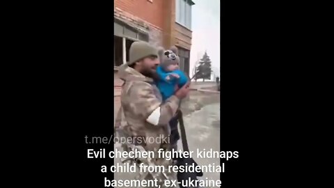 Evil Chechen fighter gently carries a child out from a basement in one of the ex-ukraine cities.