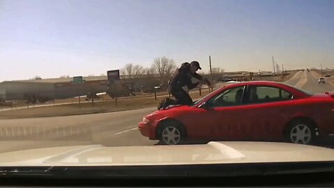 Iowa police officer clings to roof of suspect’s car during chase