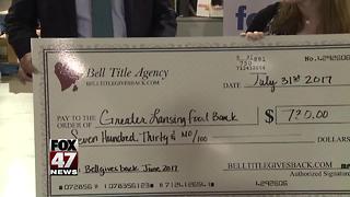 Business presents check to Greater Lansing Food Bank