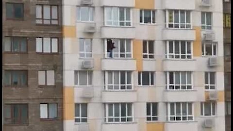 Man cleans outside window of his 18-storey high apartment