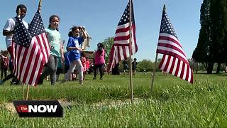 Students place flags in cemetery for Memorial Day