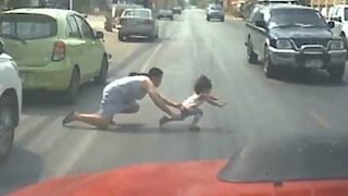 Mom jumps into busy road to save daughter