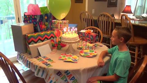 A Balloon Pops Over A Birthday Cake And Blows Out The Candles