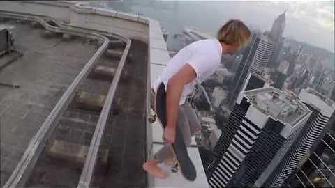 Daredevil Skateboarder Rides On The Edge Of A Skyscraper Roof