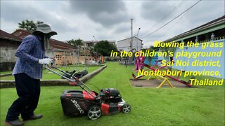 Mowing the grass in the children's playground in Sai Noi district, Nonthaburi province, Thailand