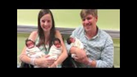 Parents pose in front of the camera with newborn triplets. But look closer at the babies’ faces