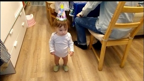 Cute baby does not know what to do on his own birthday.