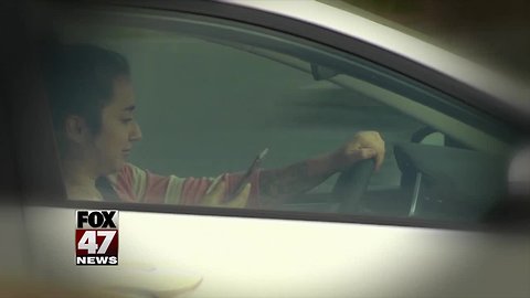 Handling a phone while driving could become illegal in Michigan