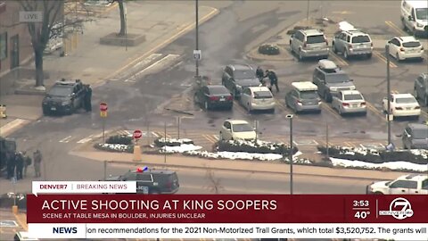 Law enforcement officers help customers leave King Soopers store in Boulder during active shooting situation