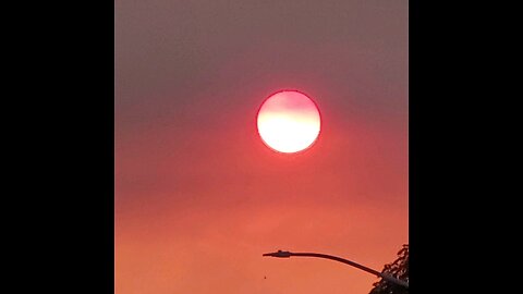 The sun turning red behind the clouds briefly