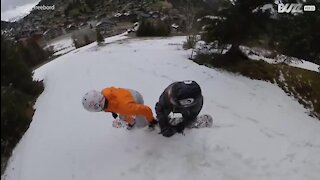Deux amis s'essaient à un snowboard en tandem