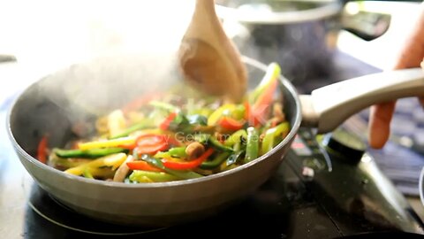 Chef stirring mushrooms, jalapeños and onion in frying