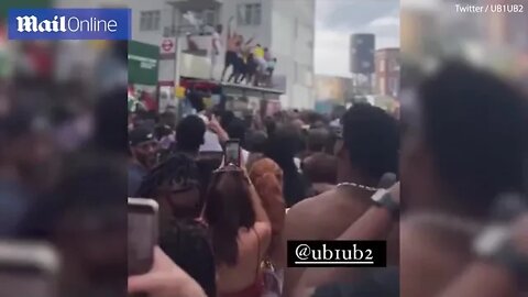 Dancing revellers crash through a bus stop ROOF near Notting Hill Carnival as partygoers enjoy event