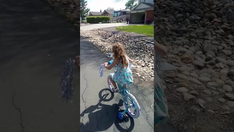 Learning to use the brakes while riding her bicycle.