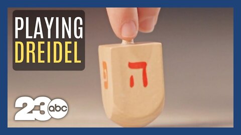 Why do we play dreidel at Hanukkah?