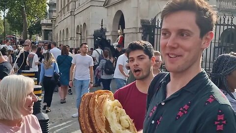 Tourist poses with the horse and has the biggest Croissant never seen #horseguardsparade