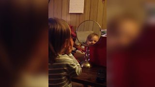 A Tot Girl Discovers Her Reflection In A Mirror