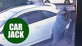Two thugs push and grab a woman on her drive way in an attempt to car jack