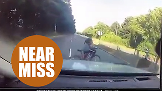Boy cyclist nearly being run over while crossing busy road