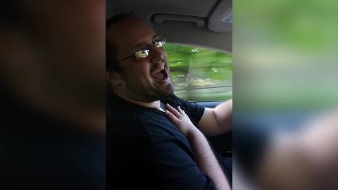 A Man Lip Syncs While Driving His Car