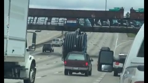 Giant Wire Spool Rolls Down A Motorway