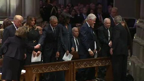 George W. Bush hands Michelle Obama a piece of candy at funeral for George H.W. Bush