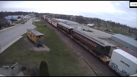EB Manifest with Two Passenger Coaches on Flat Cars at Belle Plaine, IA on April 17, 2022