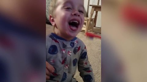 A Tot Boy Laughs While His Dad Brushes His Teeth