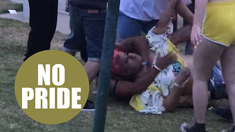 Fist fight between pink-haired man and thong-clad fellow reveller at gay pride festival