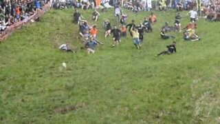 People from around throw themselves down a hill for cheese