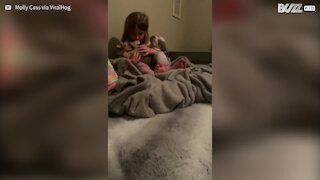 Menina adormece cachorrinho com canção de embalar