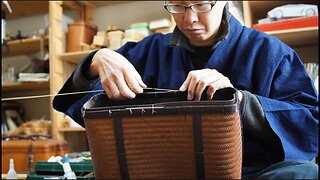 A Japanese artisan crafting a suitcase from a single bamboo culm, cloth and pieces of leather