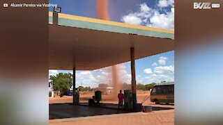 Dust devil forms next to gas station