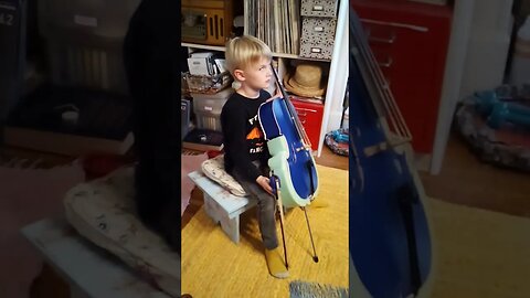 Henry, 5 yrs, "practices" tall back at the cello!