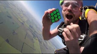 Mies ratkaisee Rubikin kuutioita vaikeissa olosuhteissa