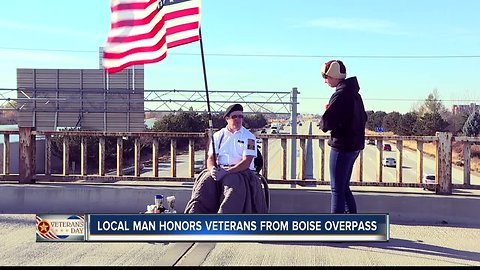 Man holds American flag to honor veterans on I-84 overpass