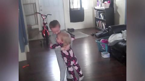 A Young Boy Dances With His Little Sister In His Arms