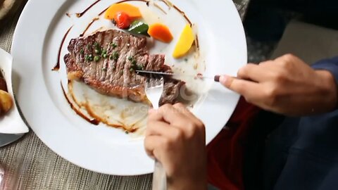 Child hands cutting piece of meat. Kid eating steak