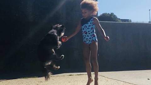 Girl and doggy jump together at the same time