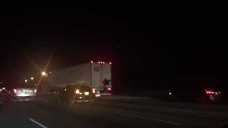 This man hitched a ride on the back of a truck on the highway