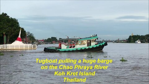 Tugboat pulling a huge barge on the Chao Phraya River Koh Kret Island Thailand