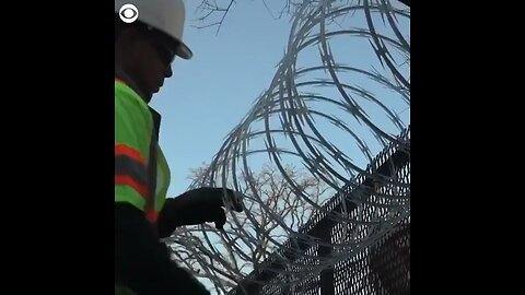 Barbed wire fences going up all around the Capital building while military stands guard